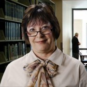 Smiling woman with a short dark bob haircut and glasses